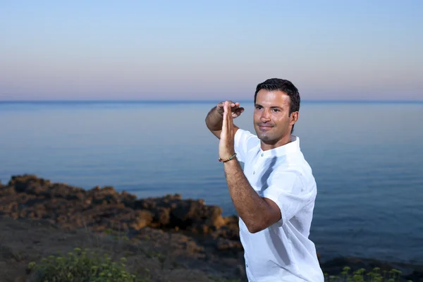 Knappe man op het strand mediteren - tai chi — Stockfoto