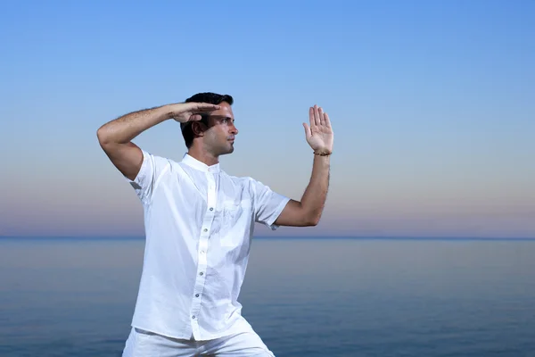 Schöner Mann am Strand beim Meditieren - tai chi — Stockfoto