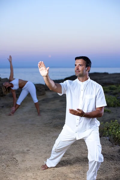 Ungt par praktisera yoga och tai chi — Stockfoto