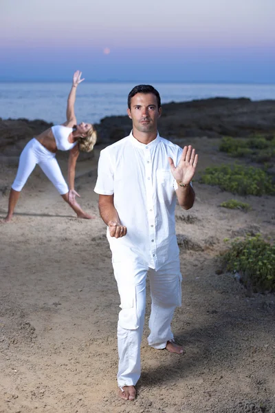 Jong (echt) paar praktizerende yoga en tai chi — Stockfoto