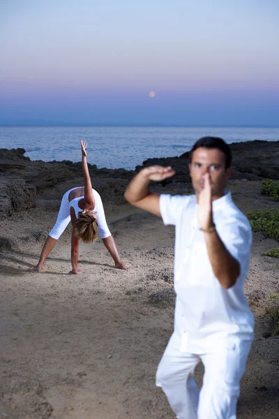 Jong (echt) paar praktizerende yoga en tai chi — Stockfoto