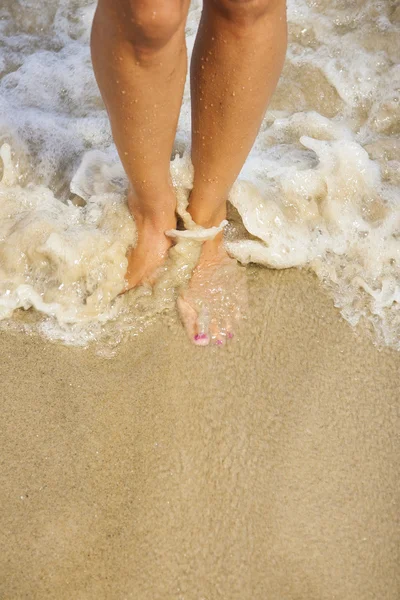 Schöne Beine eines Mädchens, das im Wasser geht — Stockfoto