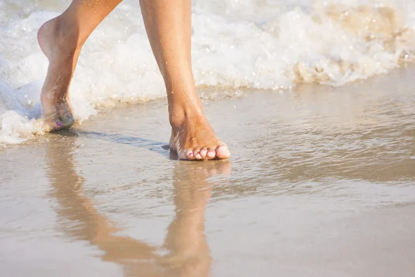 Schöne Beine eines Mädchens, das im Wasser geht — Stockfoto