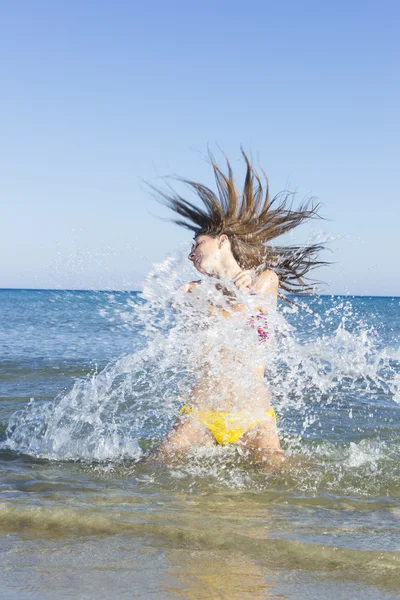 Brunett i vattnet viftande hår — Stockfoto