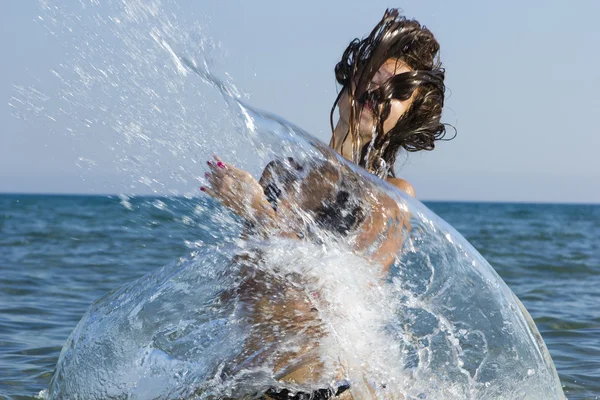 Brunette in het water haar zwaaien Stockfoto