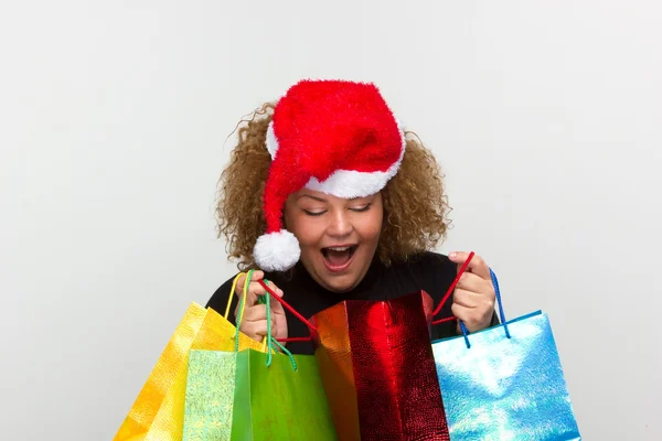 Vacker ung kvinna som bär en Tomtemössa och hålla shopping b — Stockfoto