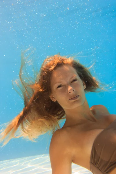 Giovane donna che nuota sott'acqua in piscina — Foto Stock