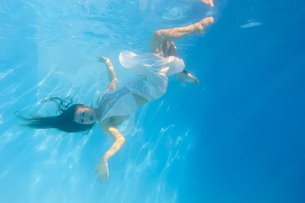 Woman in a white dress underwater in swimming pool — Stock Photo, Image