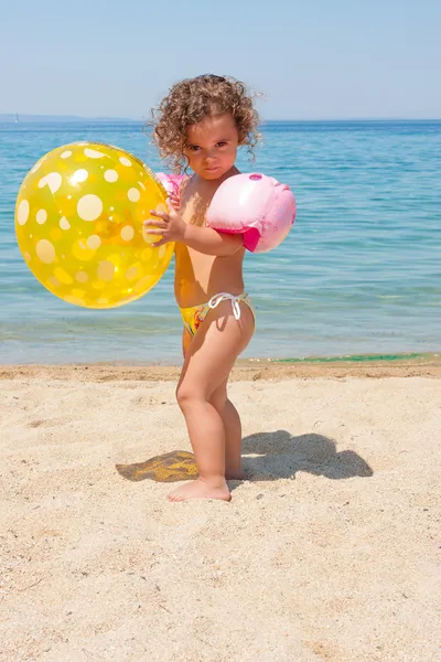 Holčička hraje s míčem na pláži — Stock fotografie