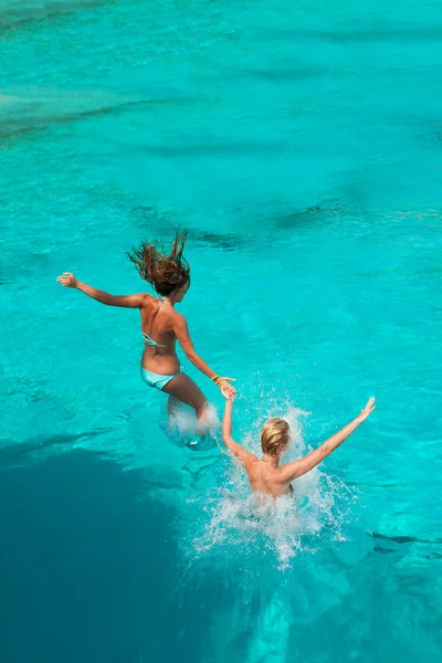 Two girls jumping in the sea — Stock Photo, Image