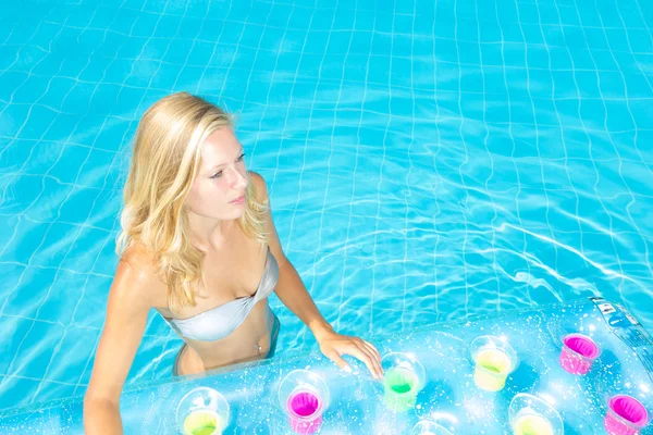 Woman relaxing at the swimming pool — Stockfoto