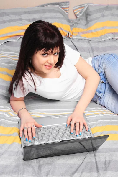 Girl in her bed looking using her laptop — Stock Photo, Image