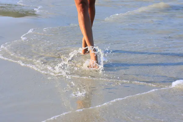 Pernas em uma praia — Fotografia de Stock