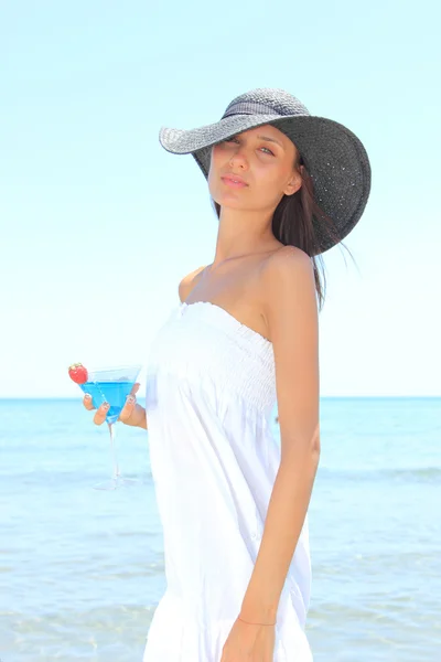 Jeune femme sur la plage avec cocktail — Photo