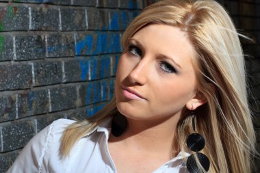 bir tuğla duvar olan genç kadın moda portre