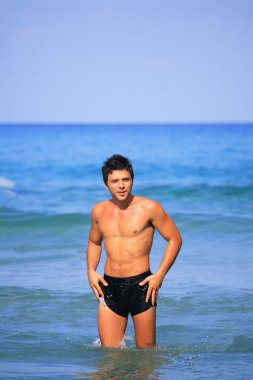 adam bir plajda poz