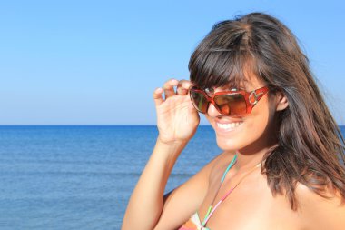 Genç güzel bir kadın sahilde poz veriyor.