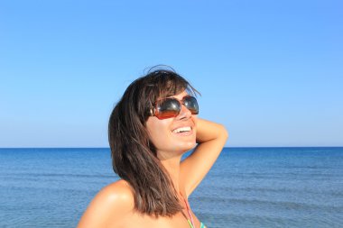 Genç güzel bir kadın sahilde poz veriyor.