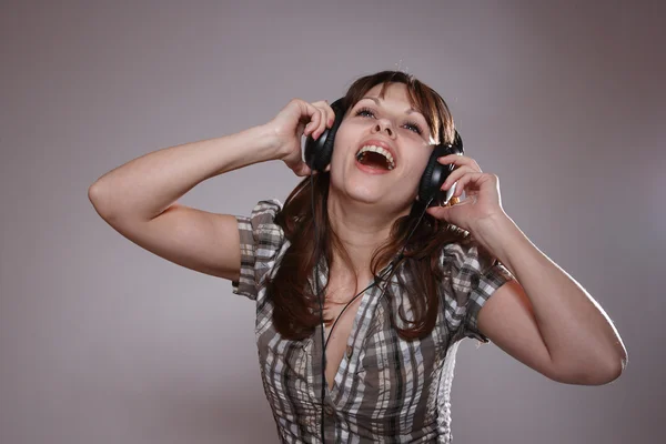 Beautiful women listening music in headphones — Stock Photo, Image