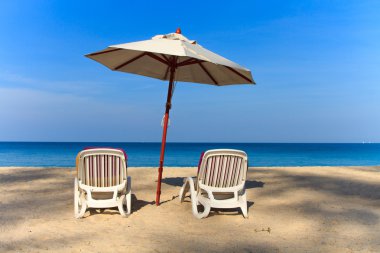 ligstoelen en parasol op het strand