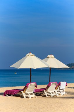 ligstoelen en parasol op het strand