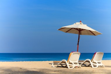 ligstoelen en parasol op het strand