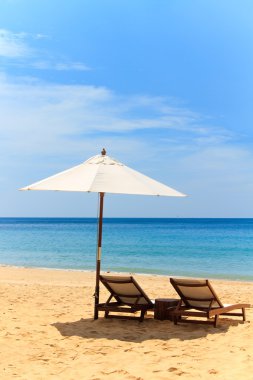 ligstoelen en parasol op het strand