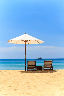 ligstoelen en parasol op het strand