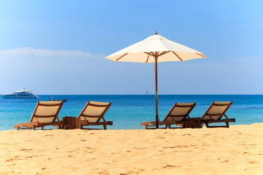 ligstoelen en parasol op het strand
