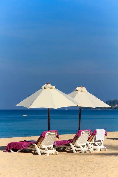 Ligstoelen en parasol op het strand — Stockfoto