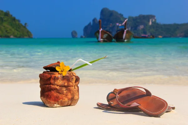 Cocktail di cocco e sandali in spiaggia — Foto Stock