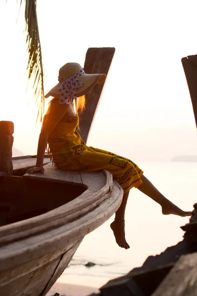 Frau im Sarong auf einem Boot mit langem Schwanz bei Sonnenaufgang — Stockfoto