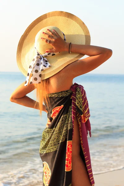 Mujer en sarong en la playa al amanecer — Foto de Stock