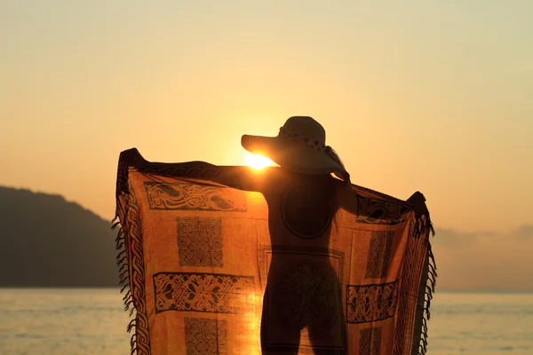 Woman in sarong on the beach at sunrise — Stock Photo, Image