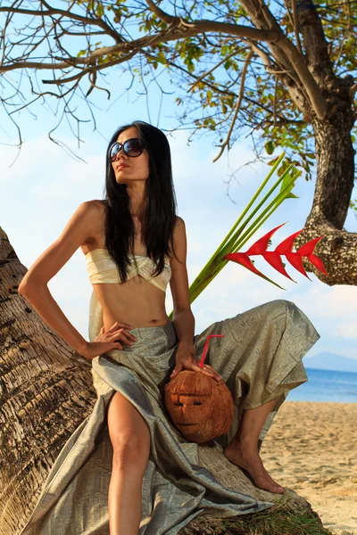 Mujer en sarong en un cocotero en la playa —  Fotos de Stock