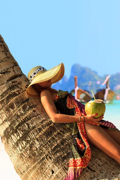 Woman sitting on a coconut tree on Phi Phi — Stock Photo, Image