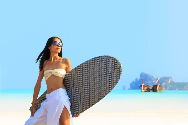 Ασιατική γυναίκα που κρατά μια σανίδα του surf σε μια παραλία — Φωτογραφία Αρχείου