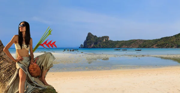 Woman in sarong on a coconut tree — Stock Photo, Image