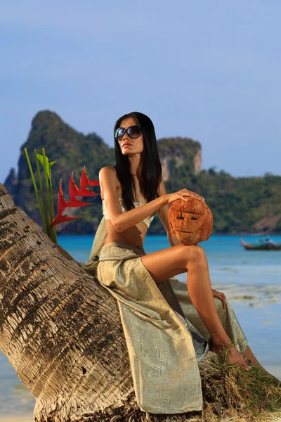 Woman in sarong on a coconut tree — Stock Photo, Image