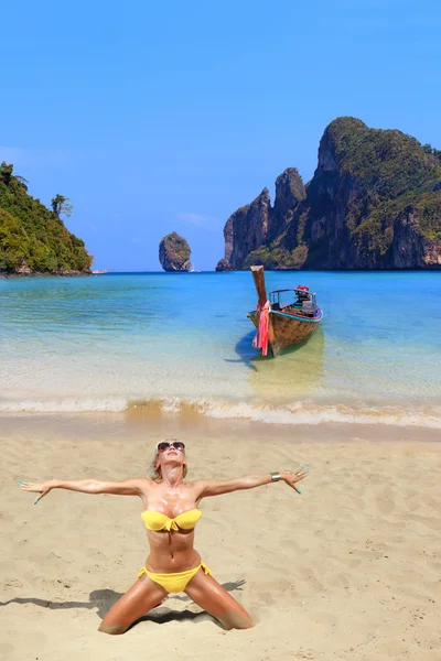 Mujer rubia joven leyendo un libro en la playa — Foto de Stock