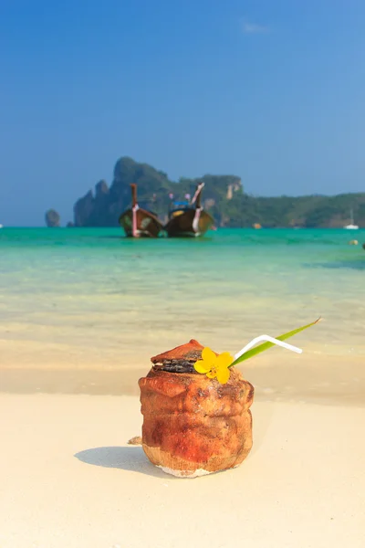 Coconut cocktail with drinking straw on the beach — Stock Photo, Image