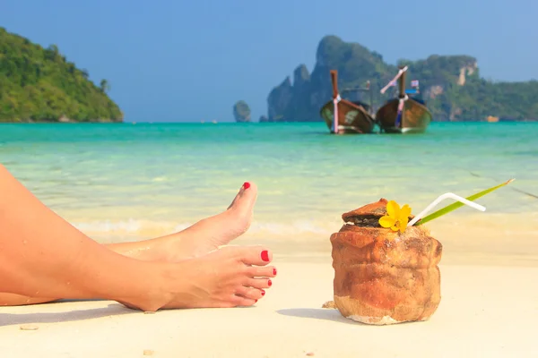 Cocktail de noix de coco avec paille à boire et jambes de femme — Photo