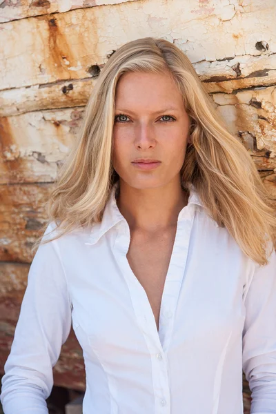 Blonde woman posing in from of shipwreck — Stock Photo, Image