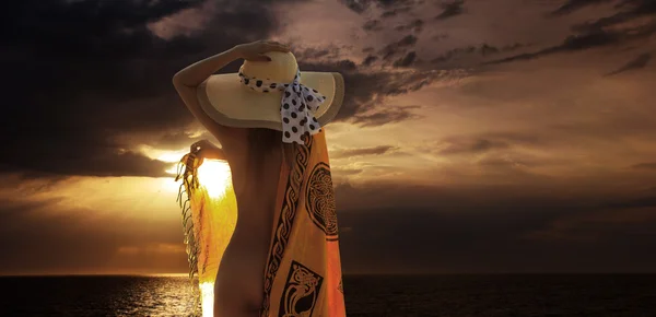 Nő a tengerparton a napkelte szárongos — Stock Fotó
