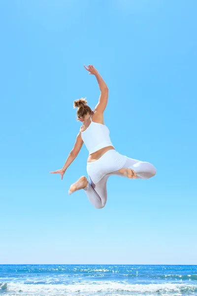 Frau springt an den Strand — Stockfoto