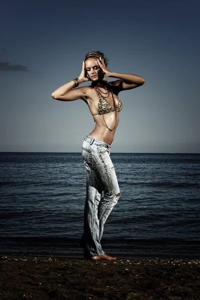 Fashion model in jeans by the sea — Stock Photo, Image