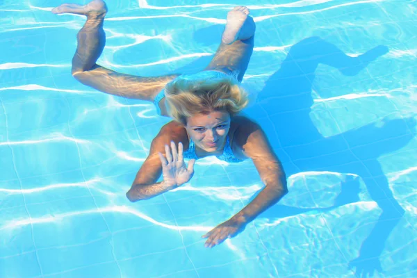 Ragazza che nuota sott'acqua in una piscina — Foto Stock