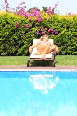 havuzun yanında şapkalı kadın