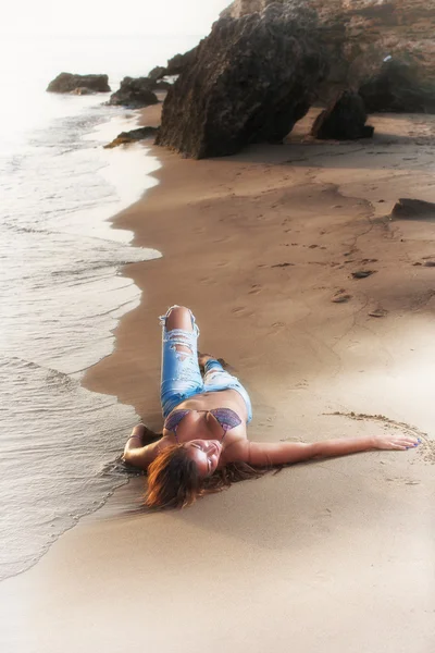 Kvinna på stranden i jeans — Stockfoto