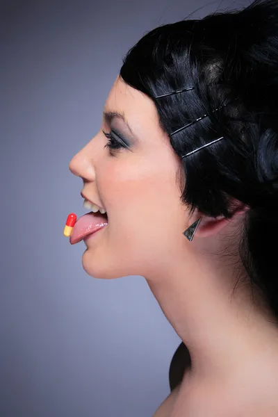 Teen girl eating pill — Stock Photo, Image